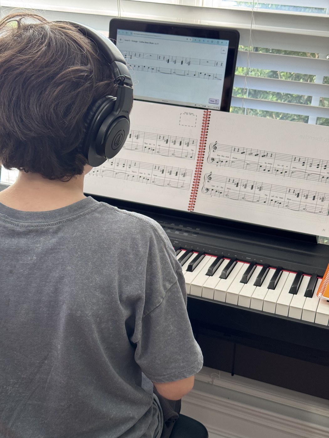 Student reading sheet music at piano